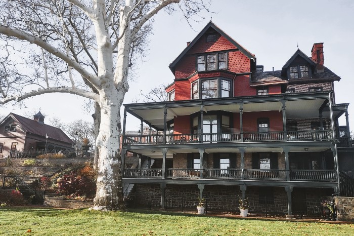 Riverside view of the Grundy estate's mansion, carriage house and gardens